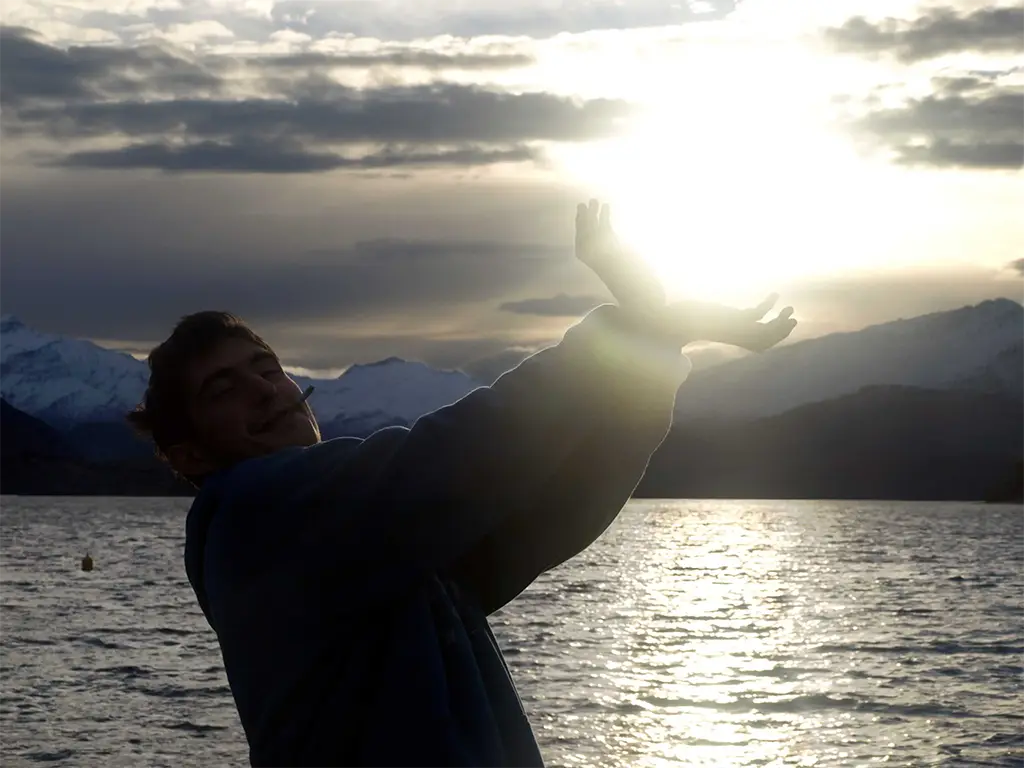 Coucher de soleil sur le lac Wanaka, en Nouvelle-Zélande, en faisant mine de tenir le soleil dans la main