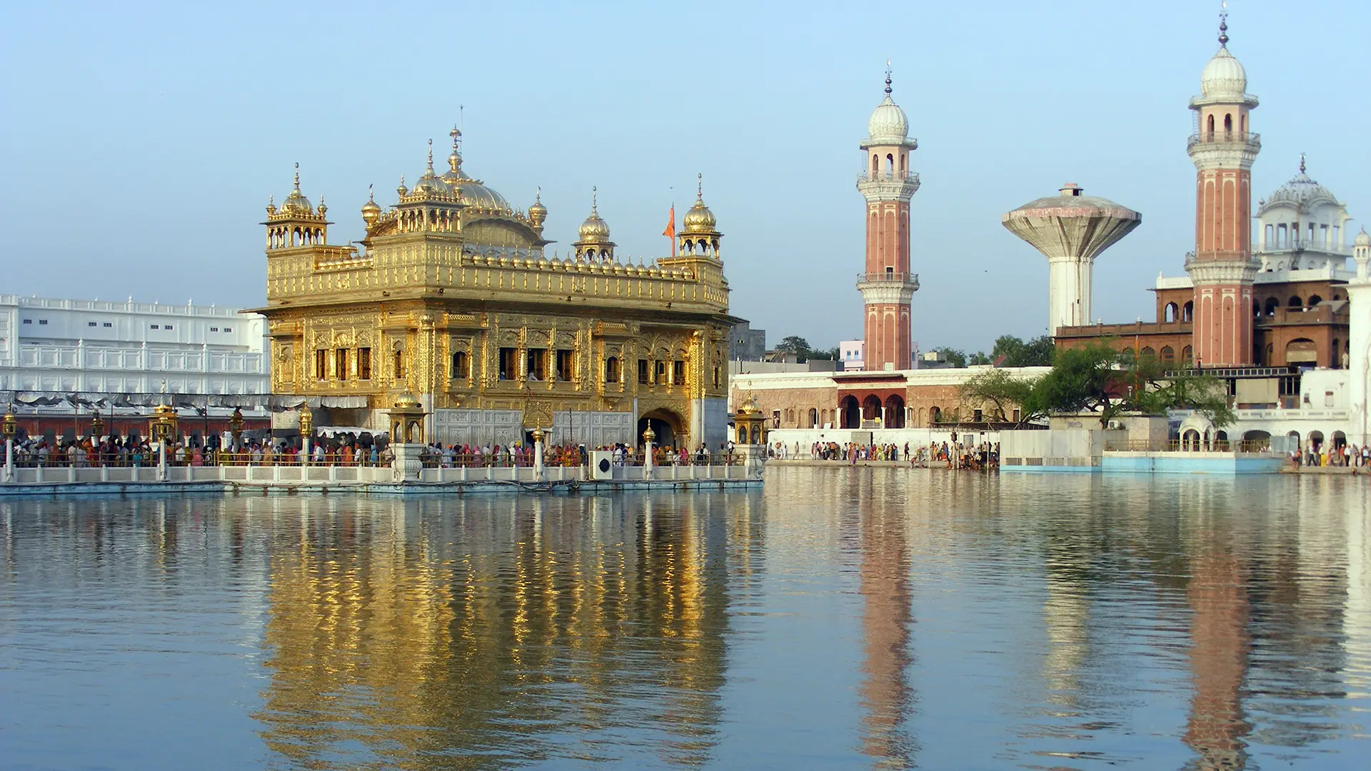 Le Temple d’Or d’Amritsar et les tours de briques du sanctuaire sikh reflétés dans le bassin sacré, en Inde