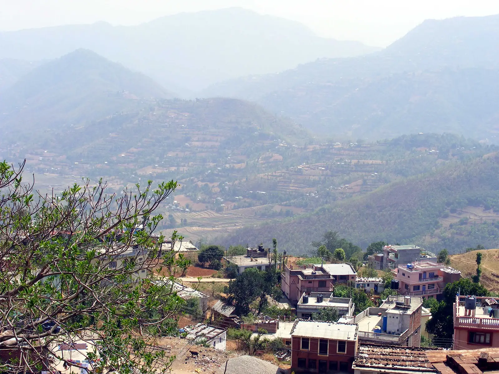 Vue des hauteurs de Tansen sur les collines en terrasses voilées de brume, au-dessus des toits de la ville